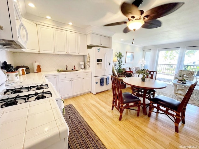 7146 Kamehameha V Hwy Unit 207C, Kaunakakai, HI 96748 - kitchen featuring tile countertops, white appliances, light wood finished floors, white cabinetry, and recessed lighting