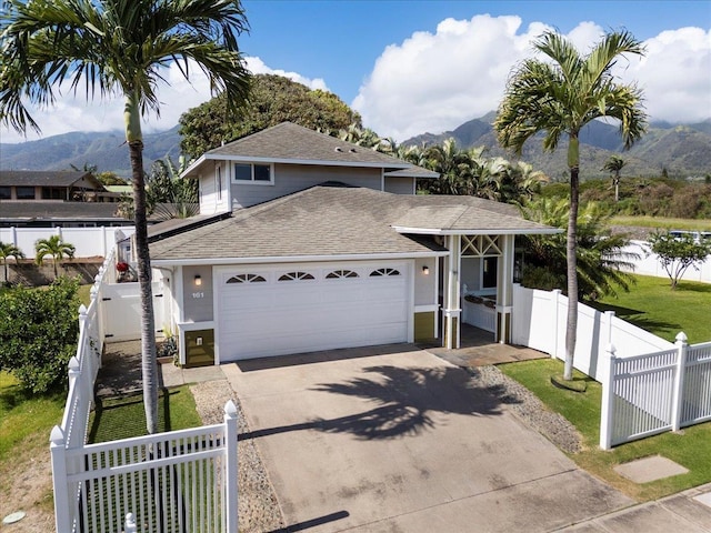 view of front of property with a mountain view, fence private yard, and an attached garage