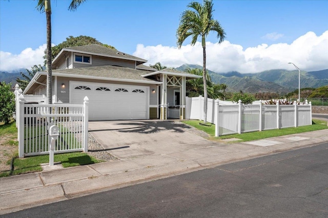 view of front facade with a gate, a mountain view, driveway, and fence