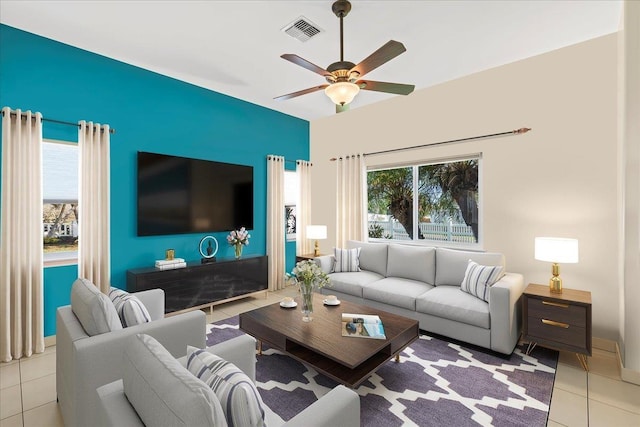 living area featuring tile patterned flooring, a ceiling fan, and visible vents