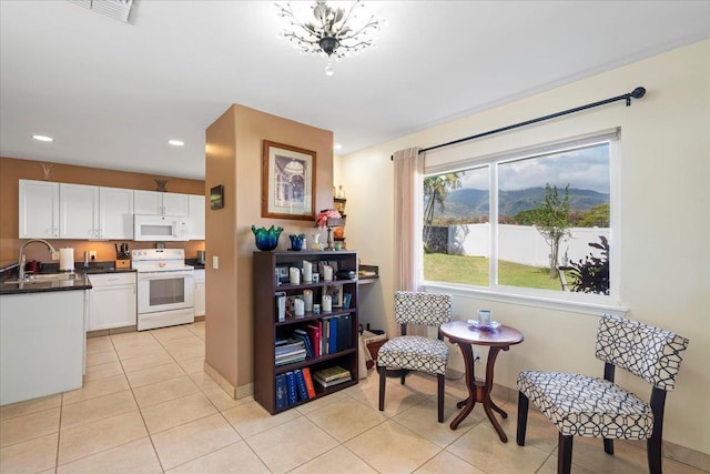 kitchen featuring visible vents, a sink, dark countertops, white cabinetry, and white appliances