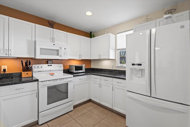 kitchen with light tile patterned floors, white appliances, white cabinets, and a toaster