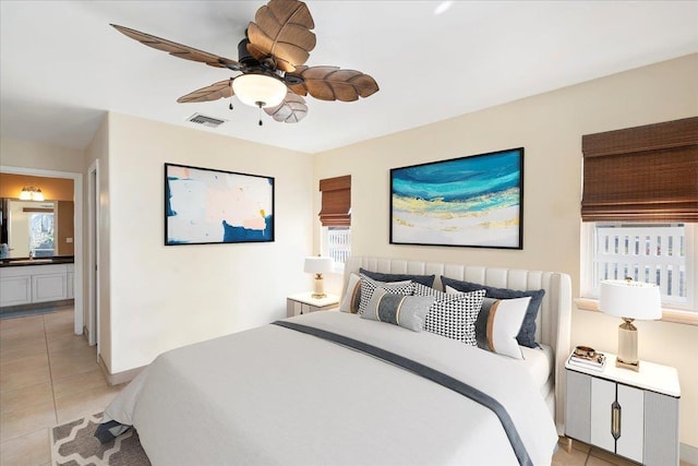 bedroom with light tile patterned floors, visible vents, ensuite bathroom, and ceiling fan