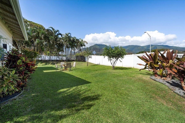 view of yard featuring a mountain view and a fenced backyard