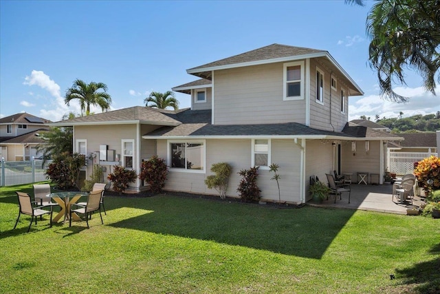 rear view of property with a patio area, a yard, and fence