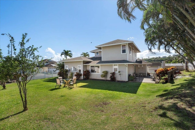 rear view of property with a patio, fence, and a lawn