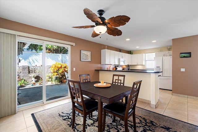 dining space with light tile patterned floors, a ceiling fan, recessed lighting, and baseboards