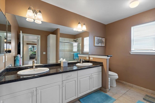 bathroom featuring tile patterned floors, a stall shower, double vanity, and a sink