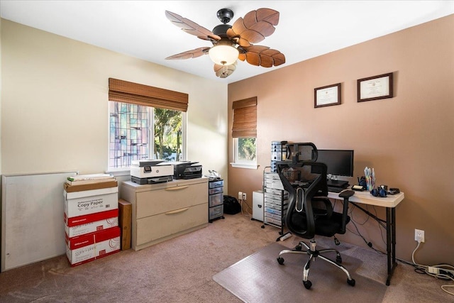 carpeted home office featuring a ceiling fan