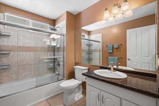 bathroom featuring tile patterned flooring, toilet, vanity, and combined bath / shower with glass door