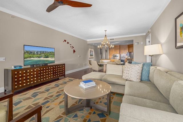 living room with wood-type flooring, ceiling fan with notable chandelier, and crown molding