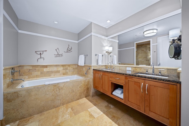 bathroom with vanity and tiled tub