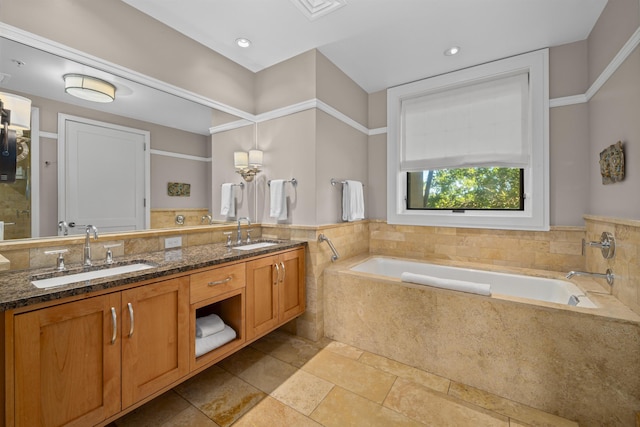 bathroom featuring tile patterned flooring, a relaxing tiled tub, and vanity