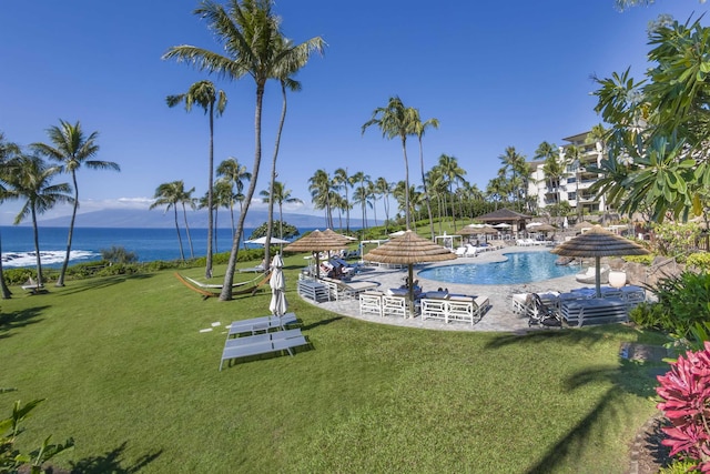 view of swimming pool featuring a water view and a yard