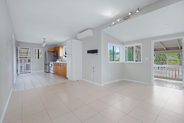 unfurnished living room featuring a healthy amount of sunlight, vaulted ceiling, a wall unit AC, and light tile patterned floors