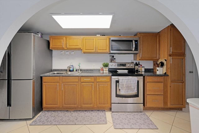 kitchen featuring appliances with stainless steel finishes, sink, and light tile patterned floors