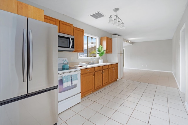 kitchen with stainless steel appliances, sink, hanging light fixtures, and light tile patterned floors