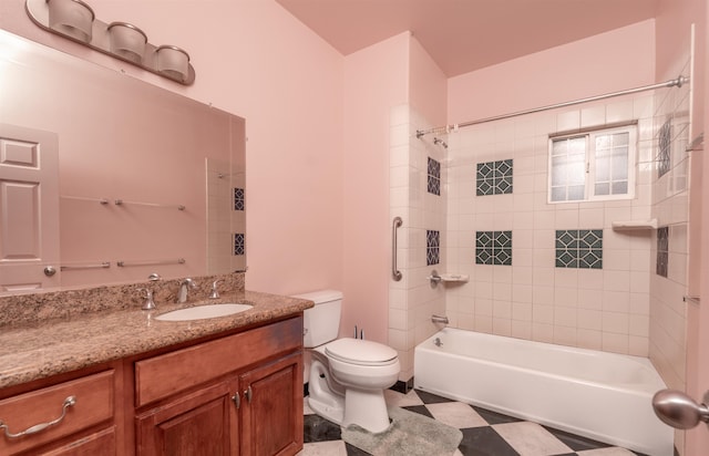 full bathroom featuring tiled shower / bath, vanity, and toilet