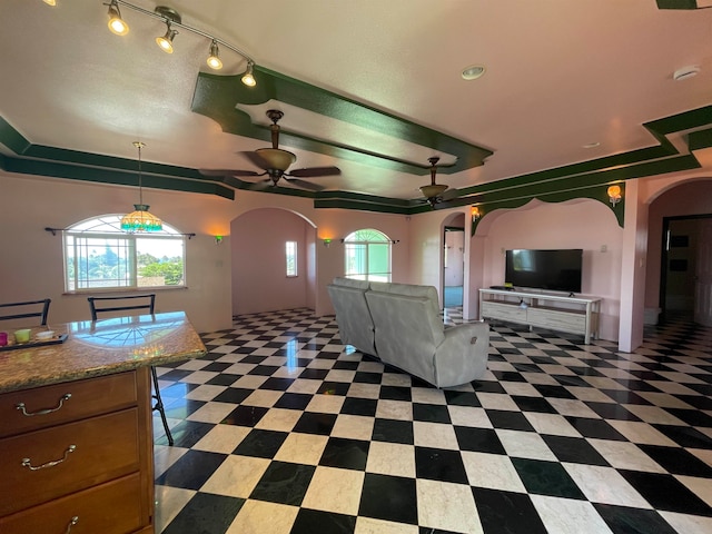 unfurnished living room featuring a wealth of natural light and ceiling fan