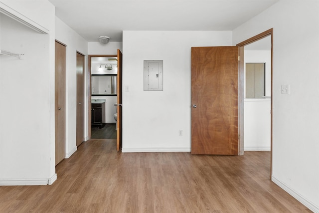 interior space with electric panel and light hardwood / wood-style floors