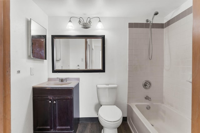 full bathroom with tiled shower / bath, vanity, toilet, and hardwood / wood-style floors