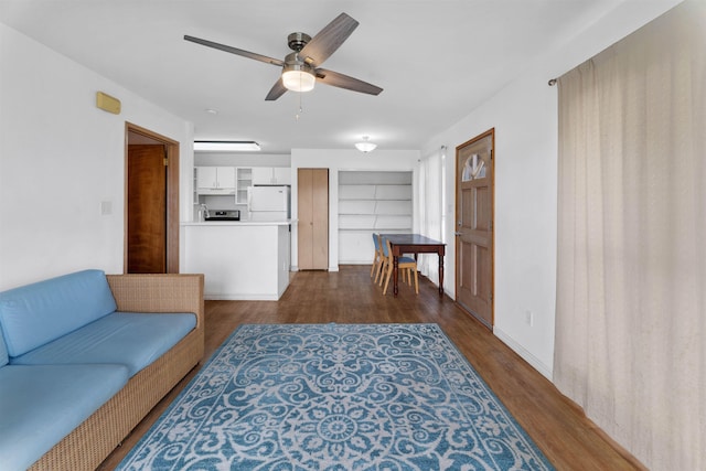 living room with dark hardwood / wood-style floors, ceiling fan, and built in shelves