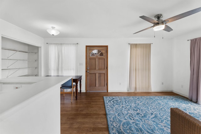 interior space featuring dark wood-type flooring, ceiling fan, and built in shelves