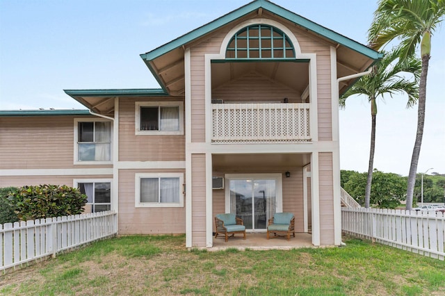 rear view of house featuring a yard, a patio, and a balcony