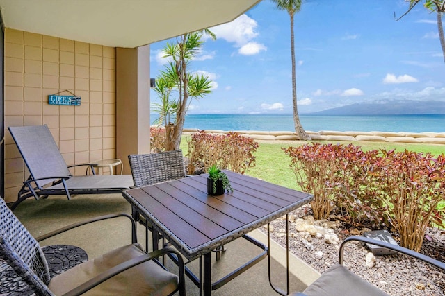 balcony featuring a water view and outdoor dining space