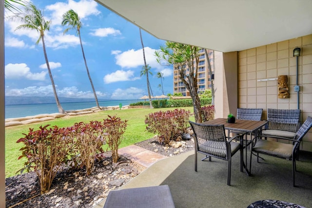 view of patio featuring a water view and outdoor dining area