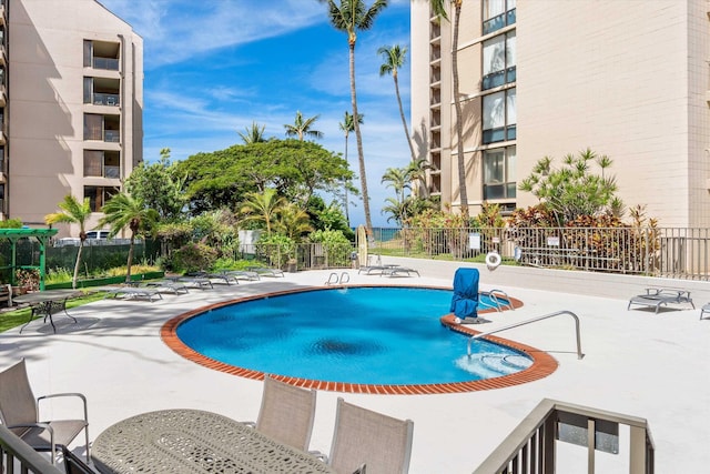 community pool featuring a patio and fence