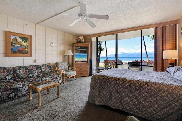 bedroom featuring a textured ceiling, carpet floors, access to outside, and ceiling fan