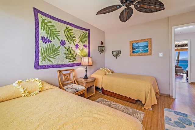 bedroom featuring ceiling fan, baseboards, and wood finished floors