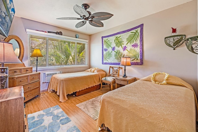 bedroom featuring a wall unit AC and light wood-style flooring