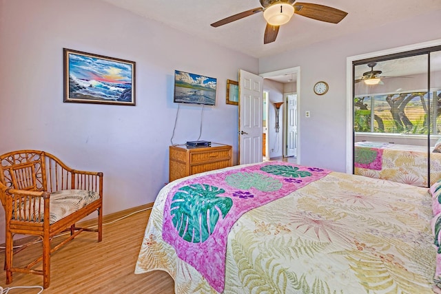 bedroom with a closet, light wood-type flooring, a ceiling fan, and baseboards