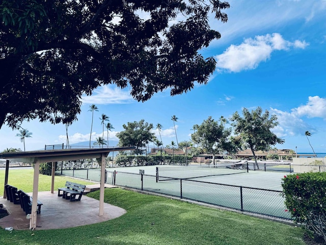 view of sport court with a yard and fence