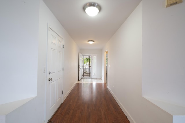 hall with baseboards and wood finished floors