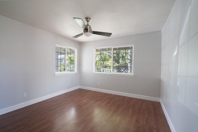 empty room featuring a ceiling fan, baseboards, and dark wood-style flooring