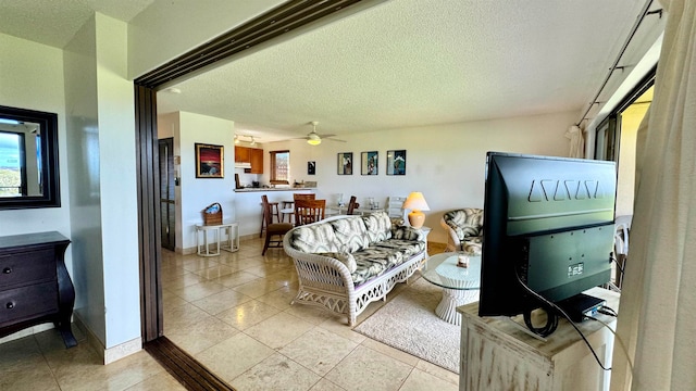 tiled living room with a textured ceiling and ceiling fan