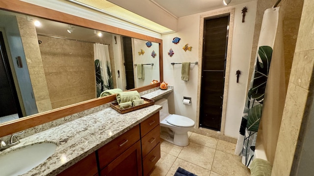 full bath with tile patterned flooring, tiled shower, vanity, and toilet