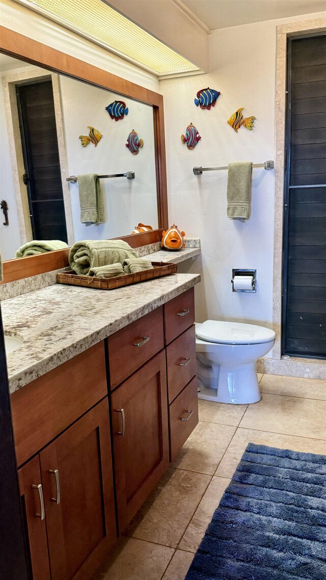 bathroom featuring tile patterned floors, vanity, and toilet