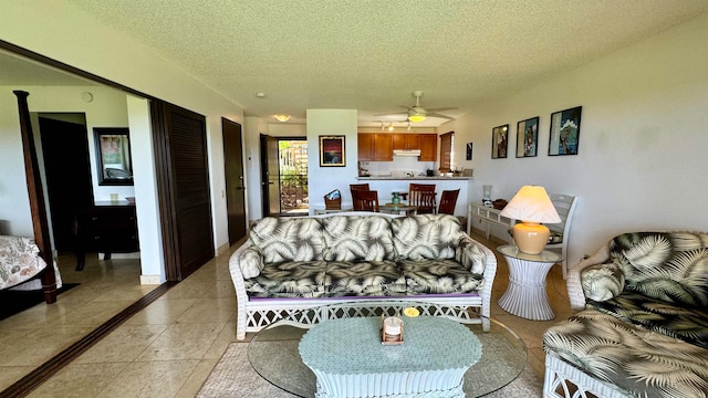 tiled living room featuring ceiling fan and a textured ceiling