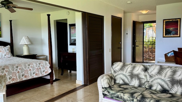 bedroom featuring ensuite bathroom, light tile patterned floors, and ceiling fan