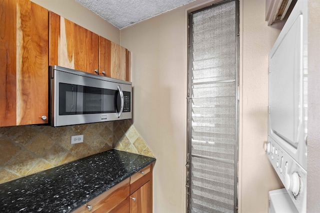 kitchen with brown cabinetry, stainless steel microwave, a textured ceiling, and decorative backsplash