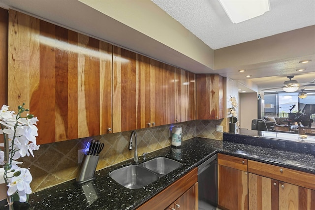 kitchen featuring brown cabinetry, a sink, decorative backsplash, and stainless steel dishwasher