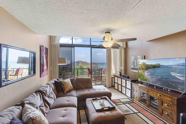 living room featuring plenty of natural light, a ceiling fan, and a textured wall