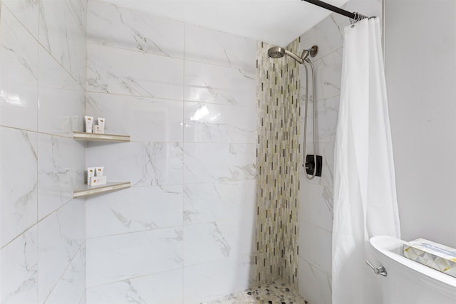 bathroom featuring a tile shower and toilet