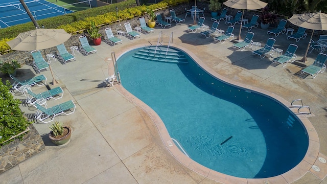 pool with a patio area and fence