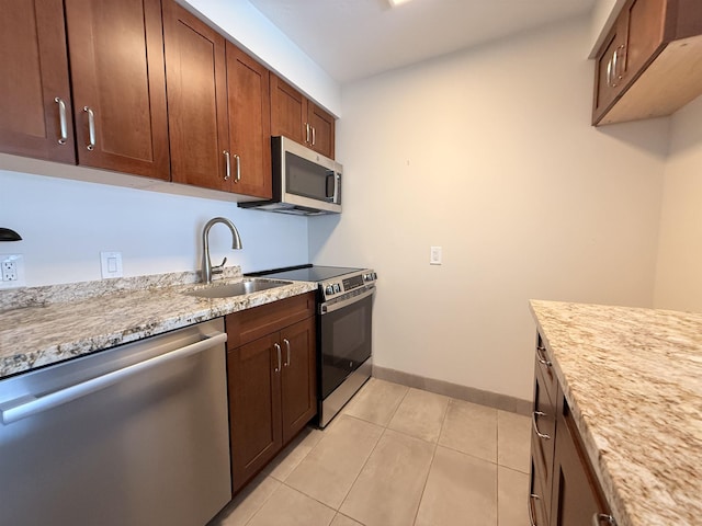 475 Front St Unit 308, Lahaina, HI 96761 - kitchen with appliances with stainless steel finishes, a sink, light tile patterned flooring, baseboards, and light stone countertops