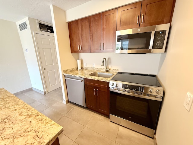 475 Front St Unit 308, Lahaina, HI 96761 - kitchen with appliances with stainless steel finishes, a sink, light tile patterned floors, light stone counters, and brown cabinets